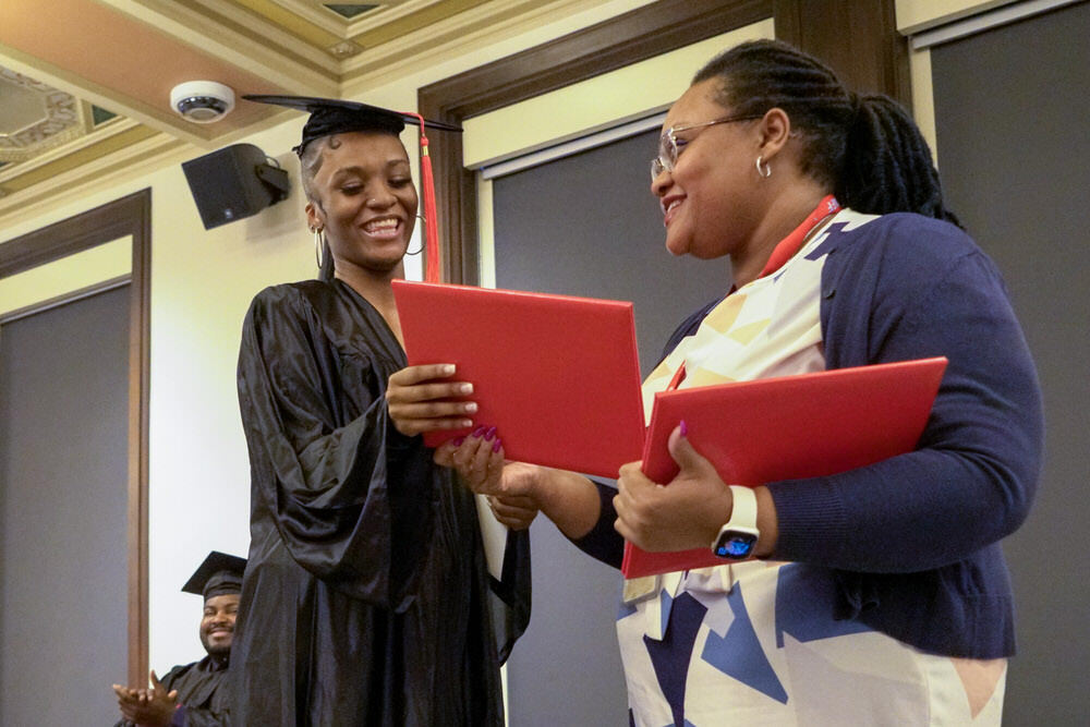 a graduate receiving her diploma from Career Online High School at Pratt Library