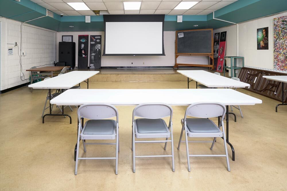 Light Street meeting room showing 3 tables, chairs, and a screen