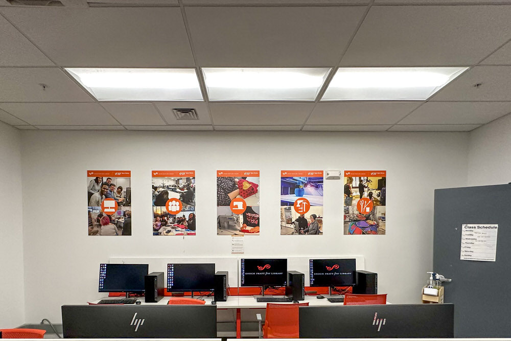 Open Works Technology Lab - Pratt Anywhere computers and wall with posters