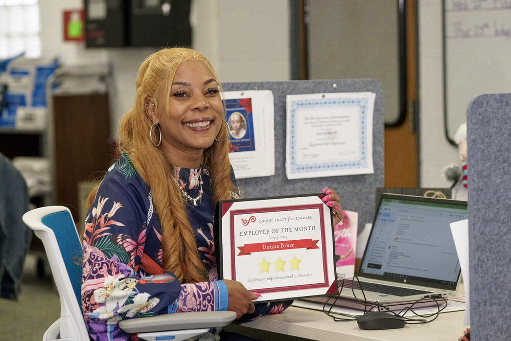staff smile with employee of the month award